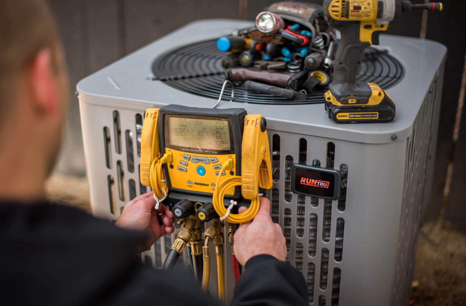 technician servicing AC unit outdoors