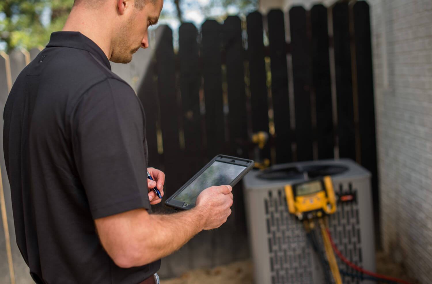 technician servicing AC unit outdoors